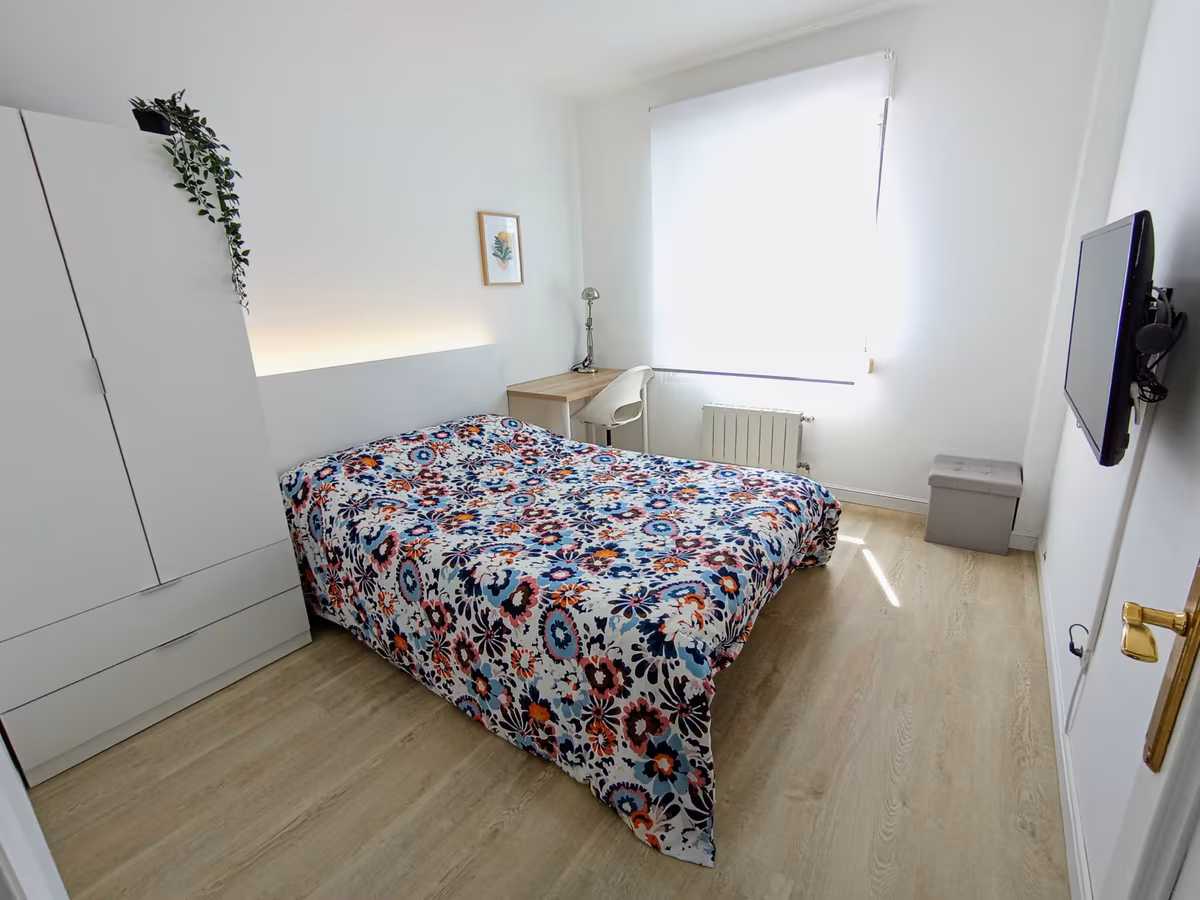 El mismo dormitorio después, en tonos blancos, con armario y escritorio